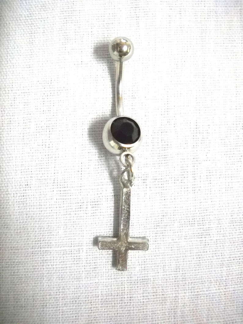 May include: A silver body piercing with a black gem and an upside down cross charm.