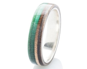 May include: A silver band ring with a green, brown and black wood inlay.