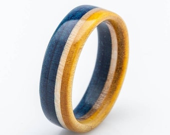 May include: A blue and yellow striped wooden ring. The ring is made from recycled skateboard wood and is waterproof. It comes with a 5 year warranty.
