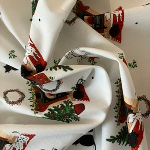 Dalmatian Dog Christmas fabric , features dogs and cats lying by a Christmas fireplace. Fabric in swirled effect