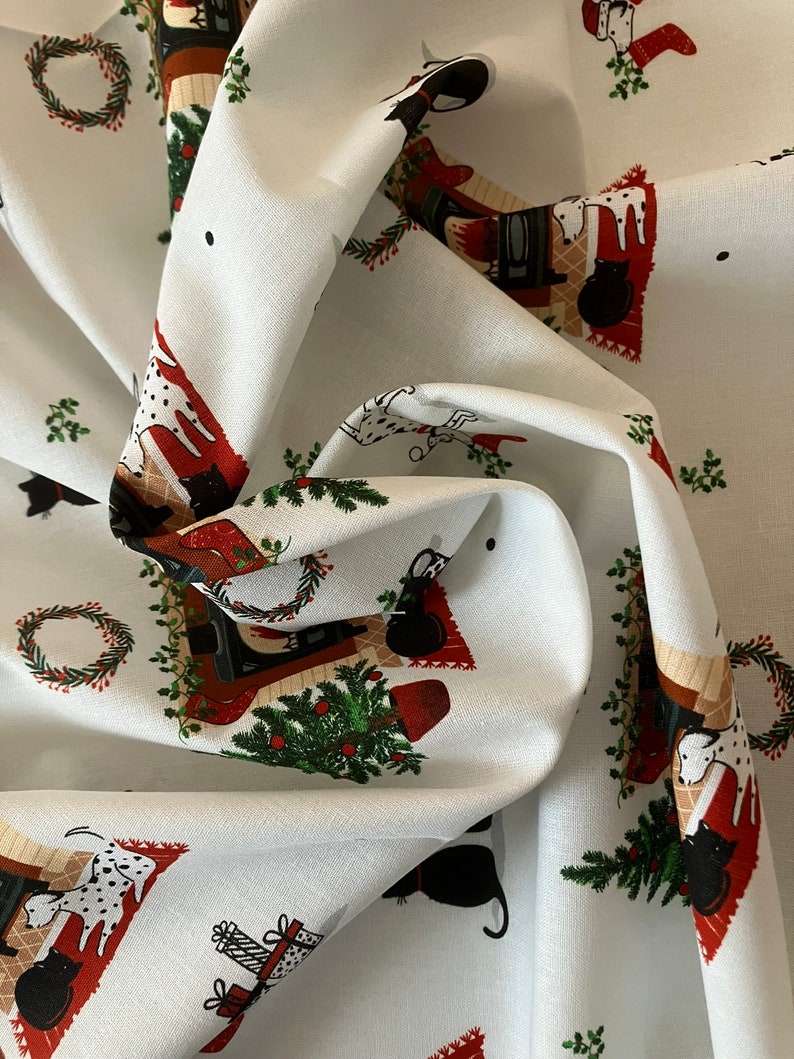 Dalmatian Dog Christmas fabric , features dogs and cats lying by a Christmas fireplace. Fabric in swirled effect