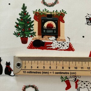 Dalmatian Dog Christmas fabric , features dogs and cats lying by a Christmas fireplace. Ruler to show size of print