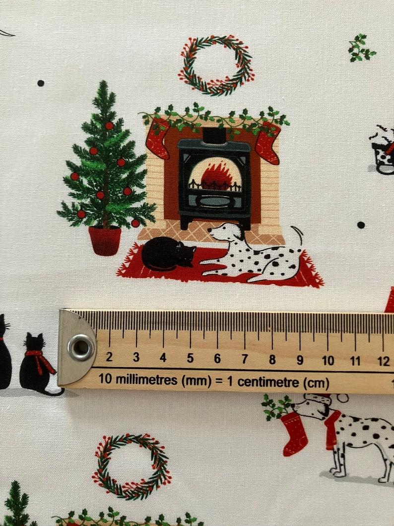 Dalmatian Dog Christmas fabric , features dogs and cats lying by a Christmas fireplace. Ruler to show size of print