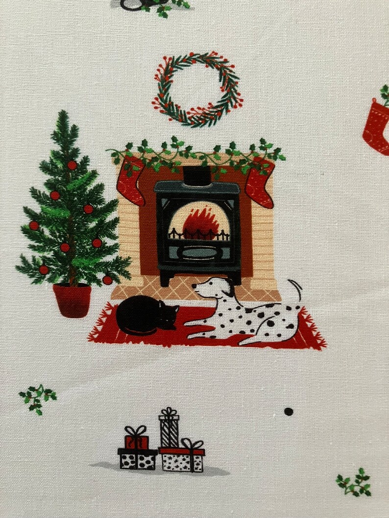 Dalmatian Dog Christmas fabric , features dogs and cats lying by a Christmas fireplace. Up close view.