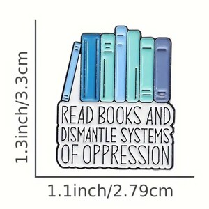 May include: A blue and green enamel pin featuring a stack of books and the text "Read Books and Dismantle Systems of Oppression". The pin measures 3.3 cm in height and 2.79 cm in width.