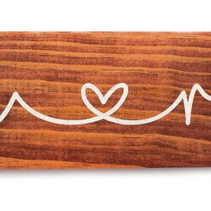 May include: Wooden sign with the words "Mama" and "Papa" connected by a heart.