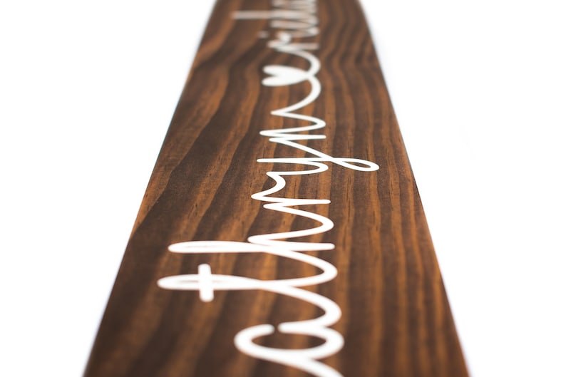 May include: A wooden sign with the words "Love my tribe" written in white cursive lettering. A small heart is included in the lettering.