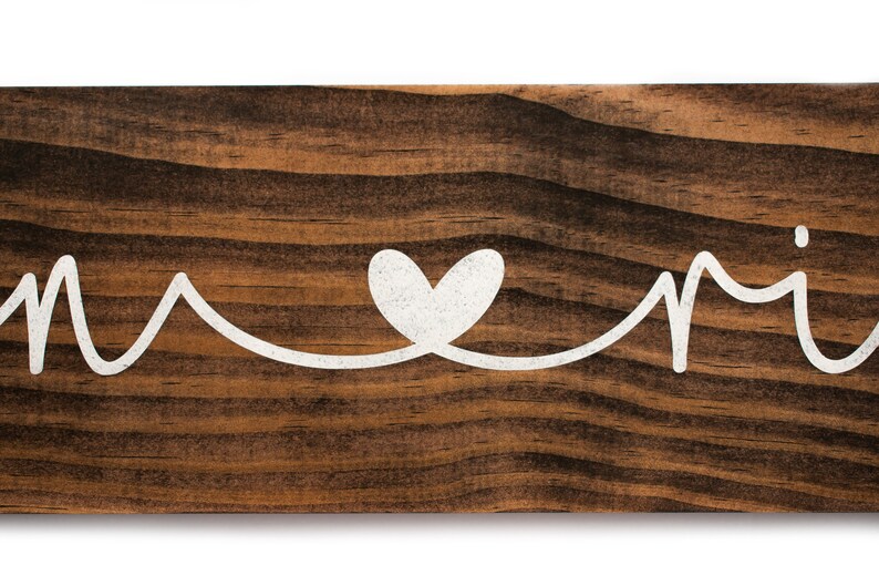 May include: Wooden sign with the words "Home" and "Sweet" written in white cursive script, with a white heart symbol between the words.