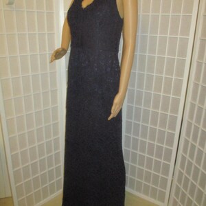 May include: A long, sleeveless, navy blue lace dress with a V-neckline.