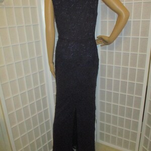 May include: A long, sleeveless, dark purple lace dress with a scoop neck and a slit in the back.