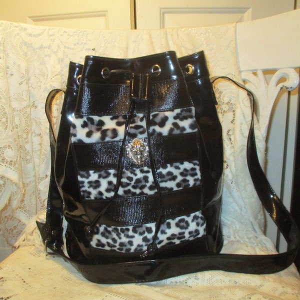 faux patent leather with leopard faux fur and lions head medallion drawstring bucket bag