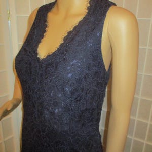 May include: A sleeveless navy blue lace dress with a V-neckline.