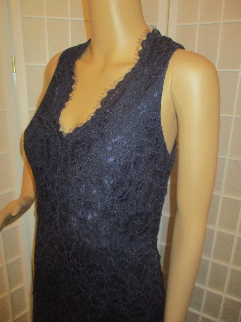 May include: A sleeveless navy blue lace dress with a V-neckline.