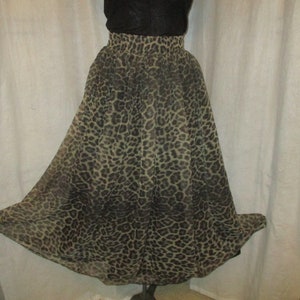 Peut inclure: Une longue jupe fluide à imprimé léopard. La jupe est en tissu transparent et a une taille élastiquée.