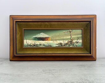 Può includere: Dipinto paesaggistico incorniciato raffigurante una scena innevata con una struttura in legno e un palo indicatore usurato. Il dipinto è incorniciato in una cornice di legno scuro con un passe-partout di velluto verde. L'opera presenta un paesaggio invernale con un edificio e un palo indicatore.