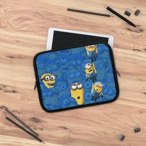 May include: A blue tablet sleeve featuring a pattern of yellow Minion characters on a blue background. The sleeve has a black zipper and a black border. The Minions are in various poses, with some smiling and others looking surprised.