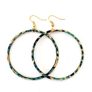 May include: A pair of large hoop earrings with gold-colored hooks. The hoops are decorated with a teal, black, and gold pattern. The earrings are displayed against a white background.
