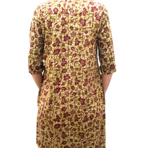 May include: A long-sleeved shirt with a floral print in shades of green, burgundy, and white. The shirt has a button-down collar and a relaxed fit.