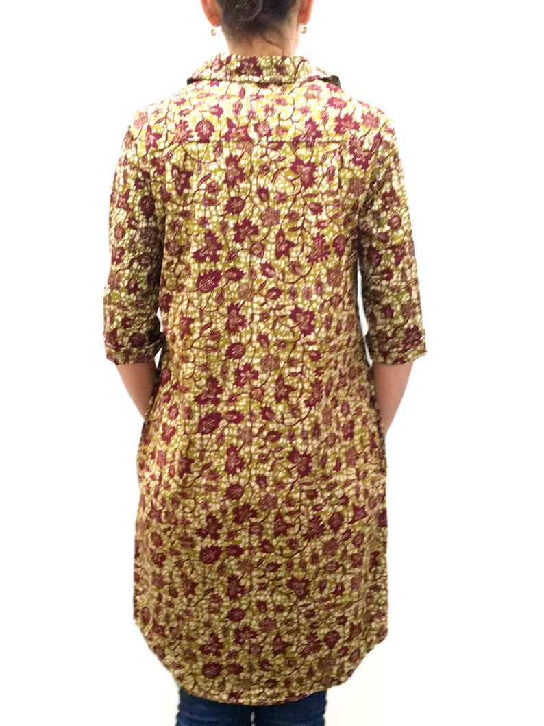 May include: A long-sleeved shirt with a floral print in shades of green, burgundy, and white. The shirt has a button-down collar and a relaxed fit.