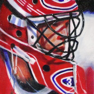 May include: A close-up of a hockey goalie wearing a red, white and blue helmet with a black cage. The helmet has a large "C" logo on the front.