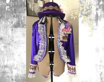 May include: A purple jacket and hat set with decorative lace trim and floral accents. The jacket features a checkerboard pattern on the collar and cuffs. The hat is adorned with gold trim. The Etsy shop name and website are displayed at the bottom.