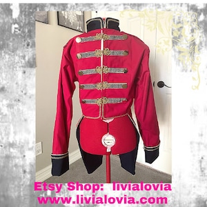 May include: A red and black jacket with gold trim and buttons. The jacket has a tailcoat style and is on a mannequin. The text "Etsy Shop: livialovia www.livialovia.com" is at the bottom of the image.