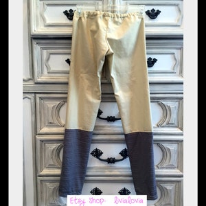 Op de afbeelding: Tweekleurige broek in beige en grijs, hangend aan een doorzichtige hanger. De broek heeft een beige bovenstuk en een grijs, getextureerd onderstuk. De elastische tailleband is zichtbaar. De Etsy shopnaam en website staan in de onderste hoek.