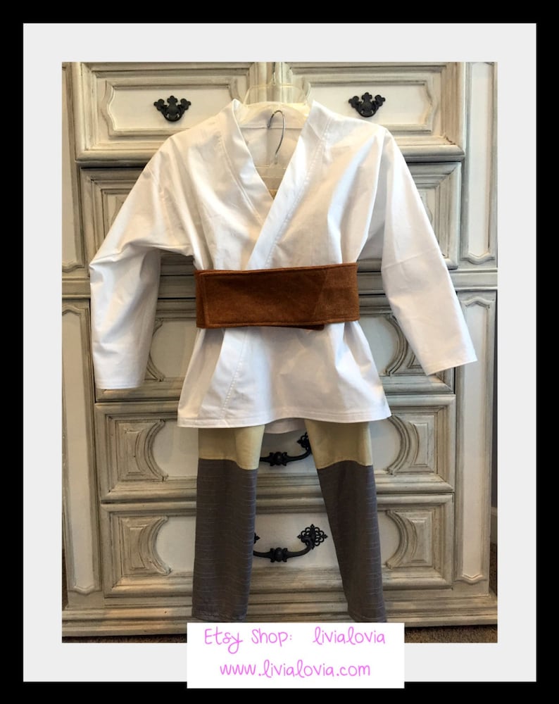 Op de afbeelding: Een wit kostuum met een bruine riem en colorblock broek. De top is een wikkelshirt. De broek heeft tan en bruine panelen. De Etsy shop naam en website zijn zichtbaar onderaan de afbeelding.