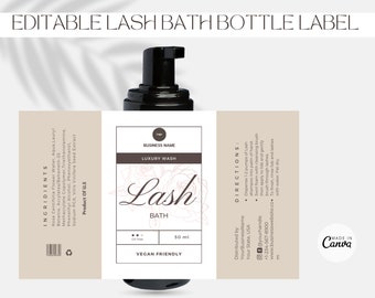 May include: A white label with brown text and a floral design for a 50 ml bottle of vegan lash bath. The label reads "Lash Bath" and "Luxury Wash". The label also includes the text "Vegan Friendly" and "Oil Free".