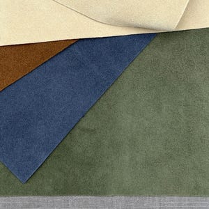 May include: Four fabric swatches in different colours: beige, brown, blue, and green. The swatches are arranged in a layered, overlapping pattern.