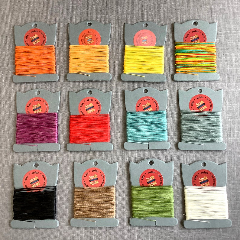 May include: Twelve spools of waxed linen thread in various colors, including orange, yellow, red, green, blue, black, and white. Each spool is labeled with "Jacks Stitchery" and "Soles & Soles".