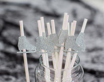May include: A bunch of white and iridescent striped straws with silver glitter ice skate toppers. The straws are in a clear glass jar.