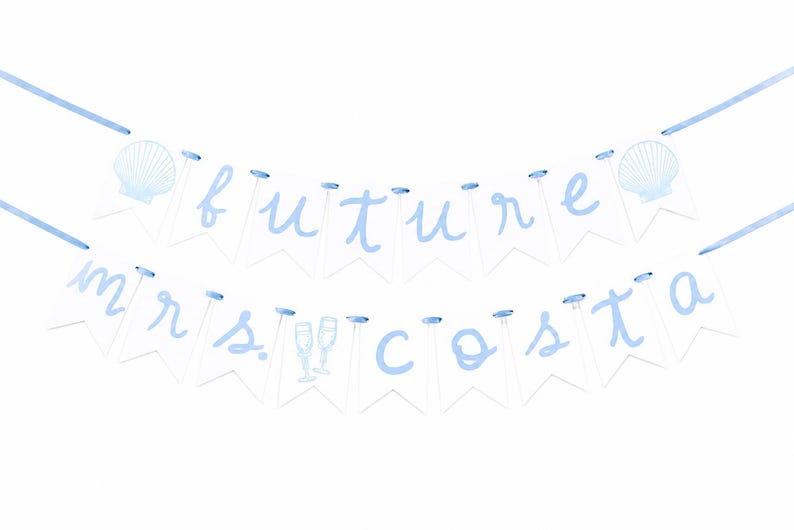 Op de afbeelding: Een tweelaagse slinger met witte vlaggetjes en lichtblauwe letters die de tekst future mrs. costa vormen. De slinger is voorzien van een lichtblauw lint, twee afbeeldingen van schelpen bovenaan en twee champagneglazen in het midden.