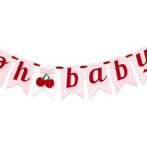 May include: A decorative banner featuring light pink pennants strung on a red cord. The letters spell out "oh baby" in a glittery red font. A white pennant in the center displays two red cherries with a small light pink bow above them.