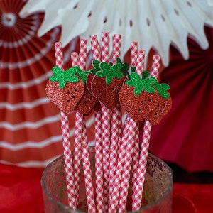 Pode incluir: Palhas de vichy vermelhas e brancas com topos de morango de glitter vermelho. As palhas est&atilde;o em um pote de vidro transparente.