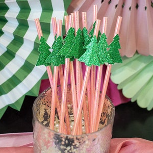 May include: Pink and green striped straws with glitter pine tree toppers in a clear glass jar with white beads.