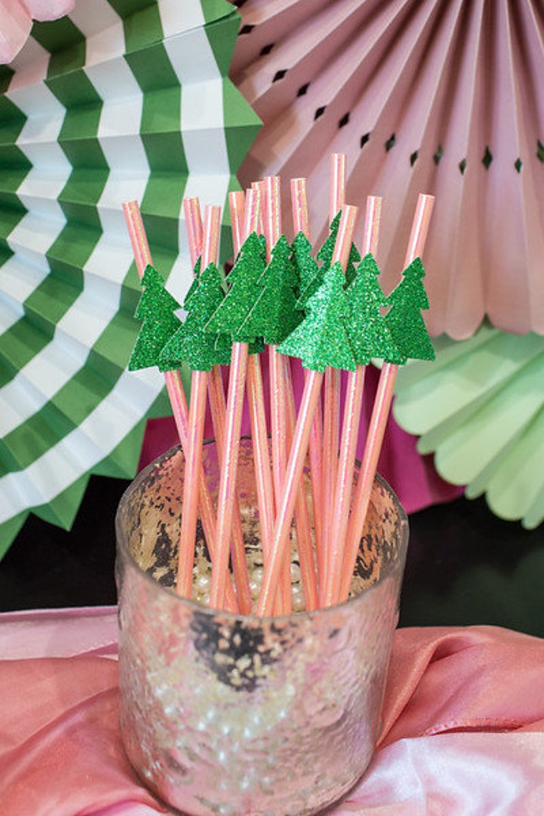 May include: Pink and green striped straws with glitter pine tree toppers in a clear glass jar with white beads.