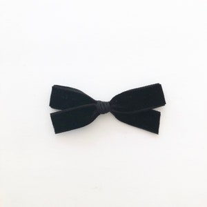 May include: A black velvet bow hair clip.