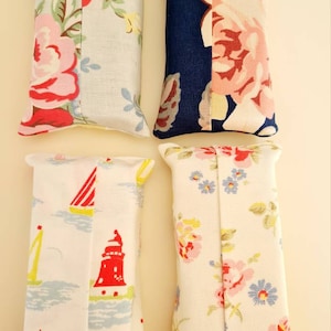 Pode incluir: Quatro capas de caixa de len&ccedil;os de tecido. Uma &eacute; azul com estampa floral branca e rosa, outra &eacute; branca com um farol vermelho e veleiros, uma &eacute; branca com estampa floral rosa e azul, e outra &eacute; branca com estampa floral rosa e verde.