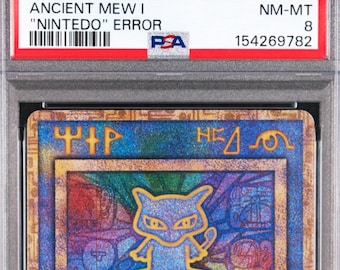 Może przedstawiać: Japońska karta kolekcjonerska Ancient Mew I z 1999 roku, oceniona przez PSA na NM-MT 8. Karta posiada holograficzny niebiesko-złoty wzór ze stylizowanymi starożytnymi symbolami oraz centralną ilustracją Mew, zamknięta w ochronnej plastikowej obudowie.