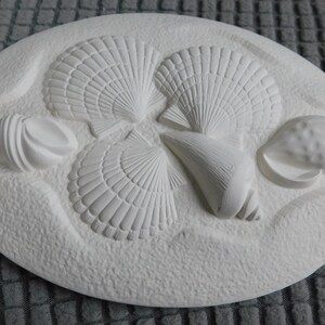 May include: A set of three ceramic mugs with a speckled, matte finish. The mugs are in shades of cream, light gray, and dark gray. Each mug has a simple, minimalist design and a rounded handle.