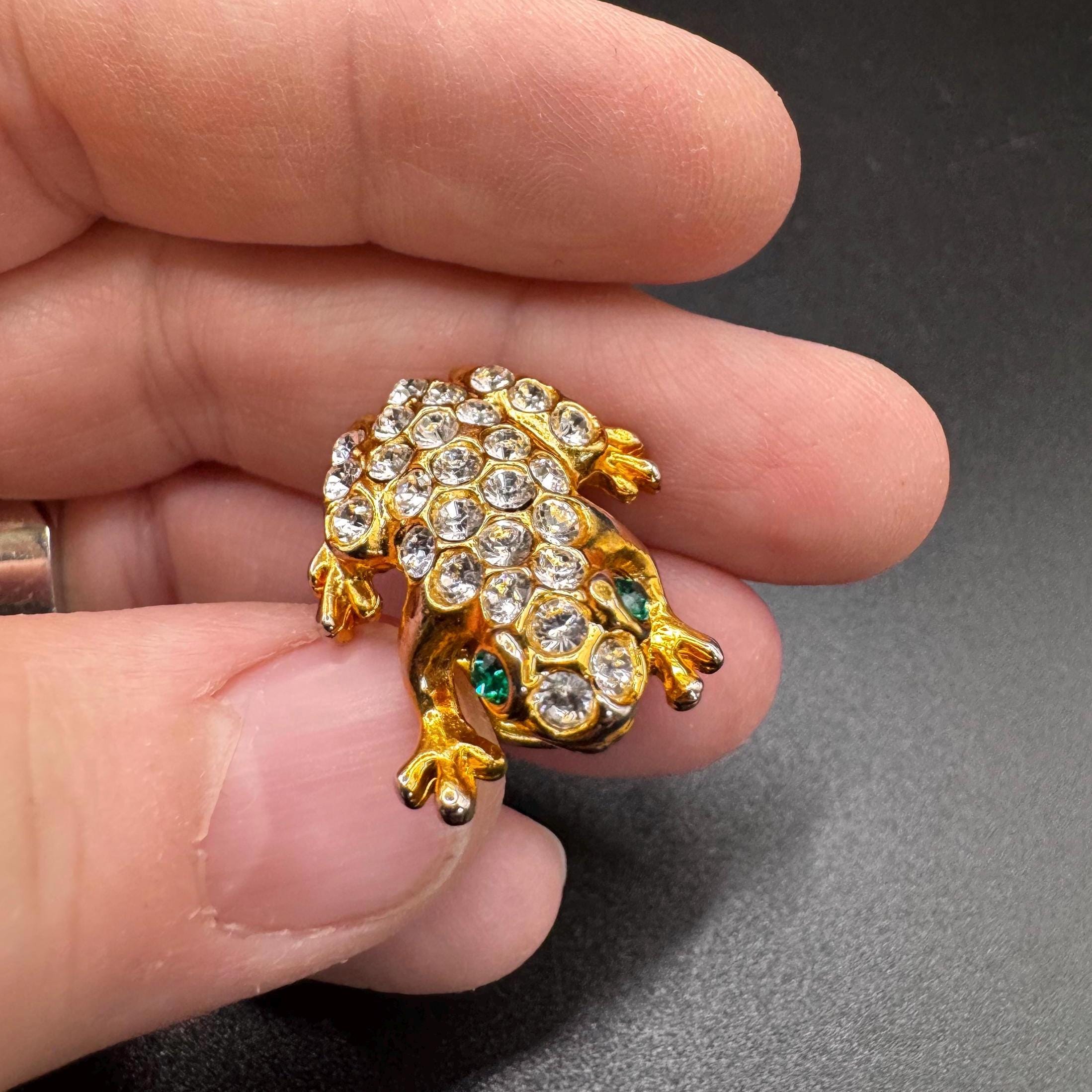 ヴィンテージのカエルのブローチ。ゴールドトーンのグリーンの目と透明