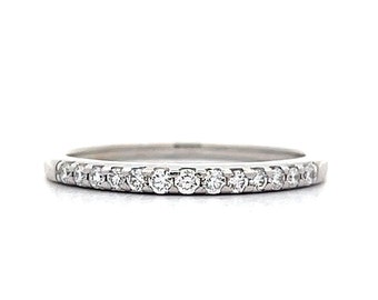 May include: A thin silver band with a row of small, clear diamonds set in a pave setting.