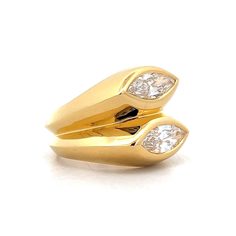 Pu&ograve; includere: Un anello d'oro con due pietre chiare a forma di marquise incastonate nella fascia.