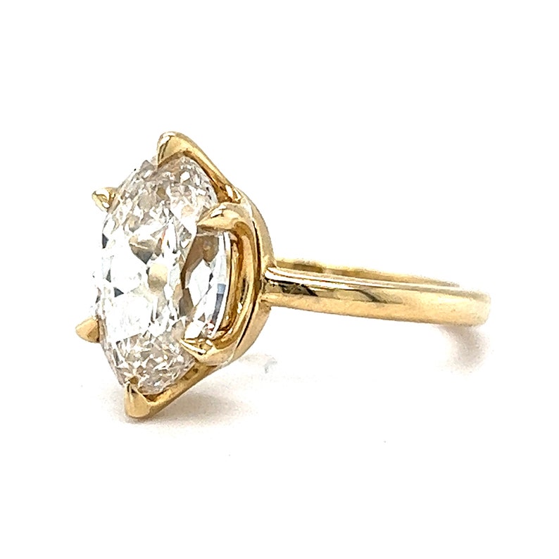 May include: A gold ring with a large, clear, round diamond set in a prong setting.