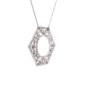 May include: A silver pendant necklace with a hexagonal frame set with clear sparkling stones. The frame has a circular opening in the center.