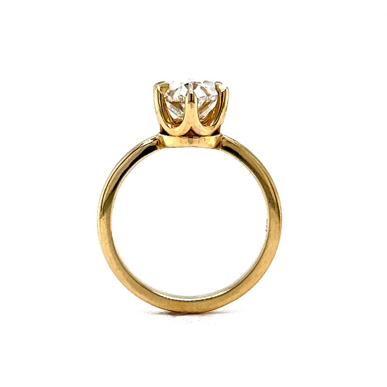 May include: A gold solitaire engagement ring with a round brilliant cut diamond set in a four-prong setting.