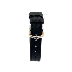 May include: Close-up of a black leather watch strap with a deployant clasp. The strap has a textured surface and is attached to a watch. The clasp is made of silver-toned metal with gold accents. The strap is suitable for a Cartier watch. The image shows the watch strap's details, including the stitching and the clasp mechanism. The strap is elegant and simple, suitable for both casual and formal wear.