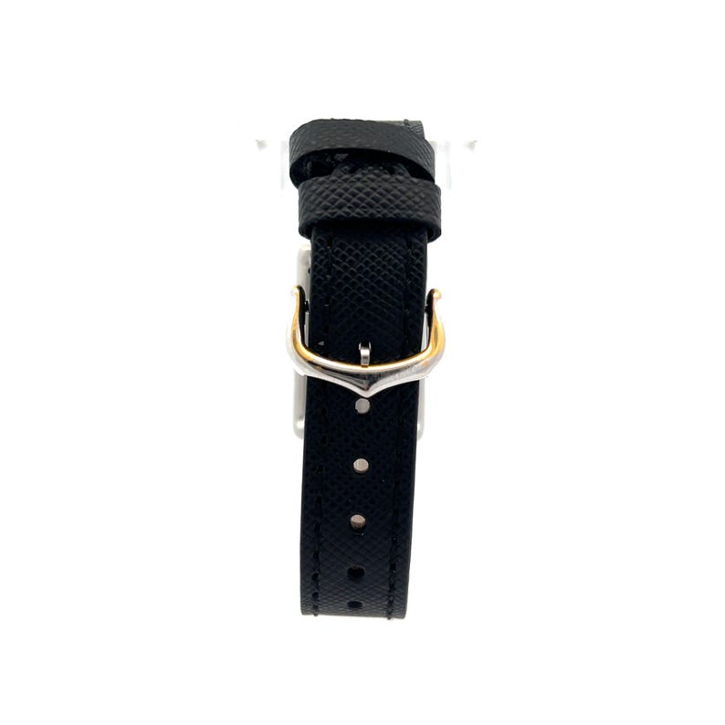 May include: Close-up of a black leather watch strap with a deployant clasp. The strap has a textured surface and is attached to a watch. The clasp is made of silver-toned metal with gold accents. The strap is suitable for a Cartier watch. The image shows the watch strap's details, including the stitching and the clasp mechanism. The strap is elegant and simple, suitable for both casual and formal wear.