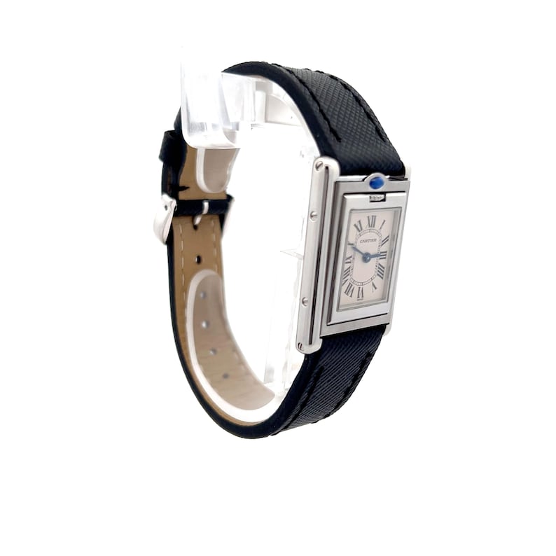 May include: Side view of a Cartier Tank watch with a black leather strap. The watch has a rectangular silver case and a white dial with black Roman numerals. The watch features a sapphire crystal and a quartz movement.  The strap has a subtle textured pattern. The watch is elegant and classic in design.